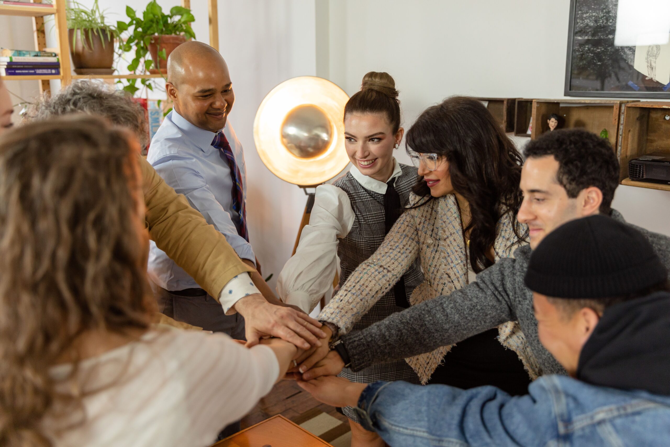 A group of diverse coworkers engage in a team huddle in a contemporary office environment